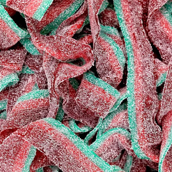 A close-up pile of sugar-coated sour gummy strips in alternating red and green stripes.